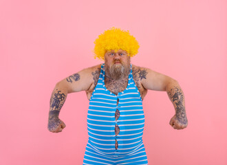 Angry man with yellow wig and swimsuit is ready to the summer