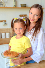 Obraz na płótnie Canvas happy mom and daughter cook and eat breakfast together