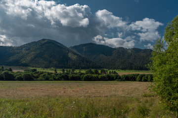 Fototapeta na wymiar Meadows and hills near Liptovska Porubka village in summer hot day