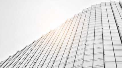 Modern architectural details. Modern glass facade with a geometric pattern. Contemporary corporate business architecture. Red sun on horizon. Black and white toned image.