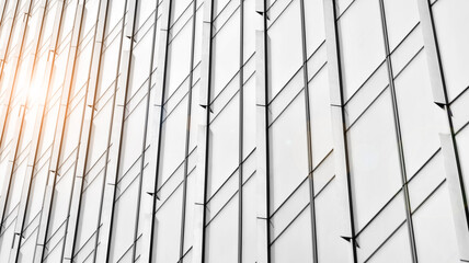 Modern architectural details. Modern glass facade with a geometric pattern. Contemporary corporate business architecture. Red sun on horizon. Black and white toned image.