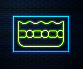 Glowing neon line Swimming pool icon isolated on brick wall background. Vector