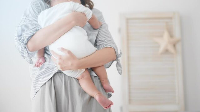 赤ちゃんを抱っこする母親　イメージ