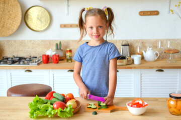 portrait of a little cute girl in the kitchen with groceries and healthy food