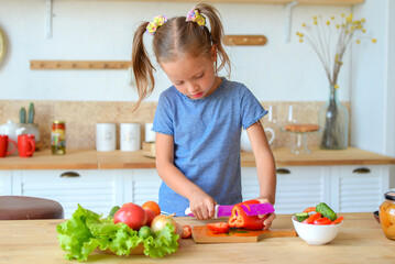 portrait of a little cute girl in the kitchen with groceries and healthy food