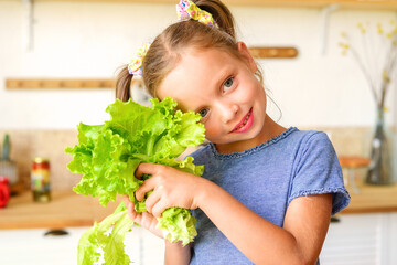 Adorable child is cooking in the kitchen. Pretty pretty girl prepares soup. Little chef preparing...