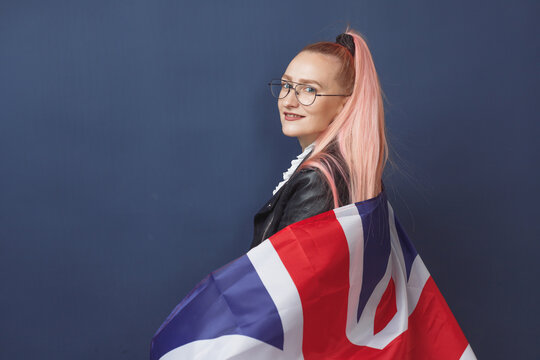 Young woman expat in eyeglasses with great britain flag. Studio shot. English language hipster teacher