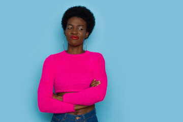Grimacing Young Black Woman In Pink Sweater Looking To The Side