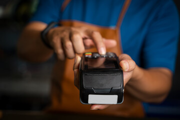 Customer using credit card for payment to owner at cafe,Payment transaction with card.
