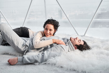 Woman laying together with her husband on the floor and laughing