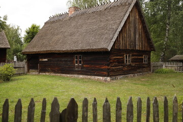 Chata drewniana rustykalna za płotem drewnianym latem