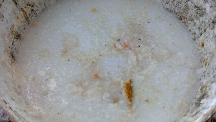 Remnants of rice left in a dirty white bucket.