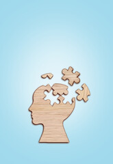 Human head silhouette with a jigsaw piece cut out on the blue background, mental health concept.