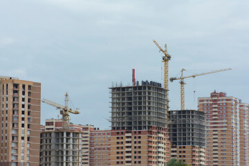 Fototapeta na wymiar construction of high-rise buildings made of bricks and concrete using high-rise cranes