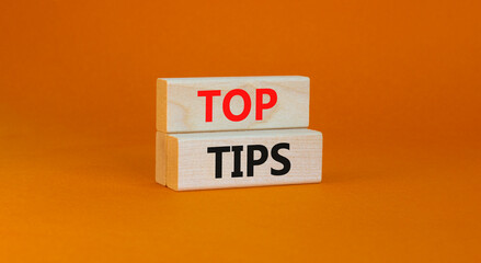 Top tips symbol. Concept words Top tips on wooden blocks on a beautiful orange background. Business and Top tips concept, copy space.