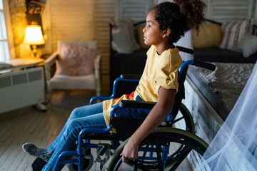 Portrait of disabled black girl with wheelchair at home