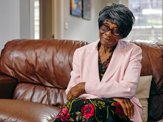 Smiling senior woman sitting on sofa