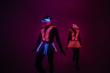 Two sexy disco dancers move in UV costumes. Parties and dances.