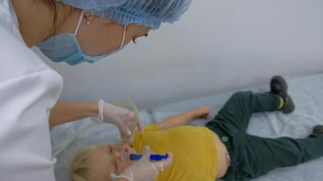 Nasal lavage method of transferring fluid. Washing the baby's nose in the clinic. The treatment of sinusitis.