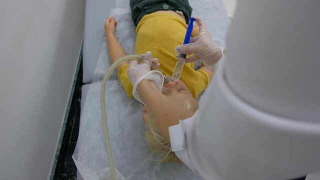 Nasal lavage method of transferring fluid. Washing the baby's nose in the clinic. The treatment of sinusitis.