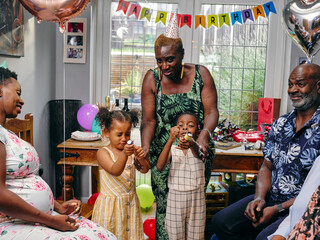 Girls using party poppers at family birthday party