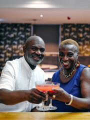 UK, Portrait of mature couple holding cocktails at bar counter