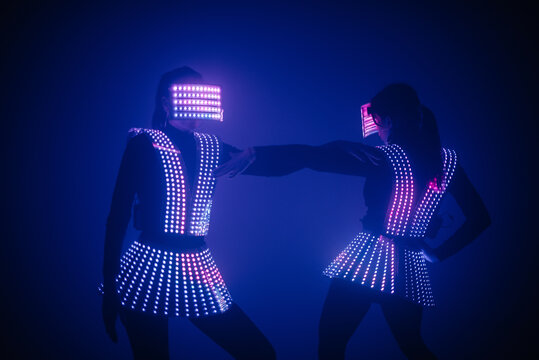 Two sexy disco dancers move in UV costumes. Parties and dances.