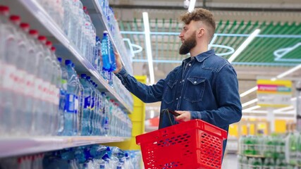 male shopper is buying bottled water in supermarket