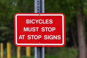 Street Sign that  says "Bicycles Must Stop At Stop Signs"