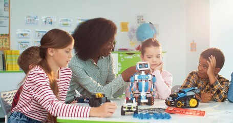 Young beautiful African American woman working in school helping multiethnic children make toys, learning about mechanics. Elementary school teacher with junior students in science class, close up - Powered by Adobe