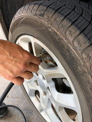 Man calibrating car tire - closeup on hand