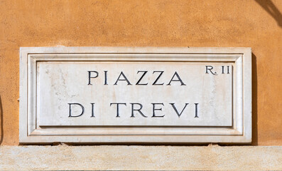 marble plate with Street name piazza di Trevi- engl: town square of Trevi -  at the wall in Rome