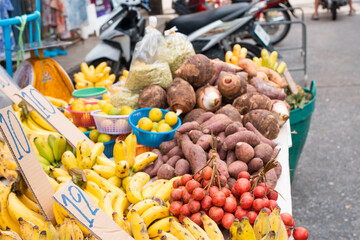 Asian market in the rows colorful fruit and vegetables.street food market with fruit. Fruit market on the street in Bangkok, Thailand.