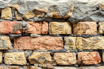 Broken decay old plaster of brick stone wall texture. Damaged erosion bumpy gloomy facade. 