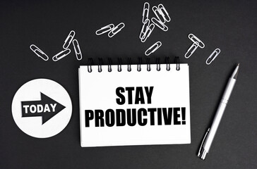 On a black background, a round plate - Today and a notebook with the inscription - Stay Productive
