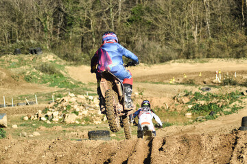 Boy on motocross motorcycle chasing another
