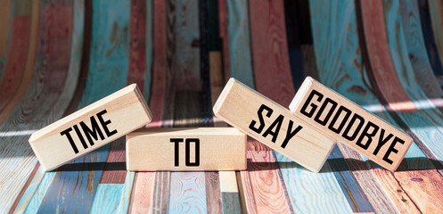 Text TIME TO SAY GOODBYE on wooden blocks and bright striped background - obrazy, fototapety, plakaty