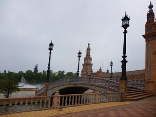 Fototapeta na wymiar Panoramic view of the bridges area, part of the Plaza de España in Seville. A tourist afternoon where you can see the canal and one of the bridges, a very colorful special floor