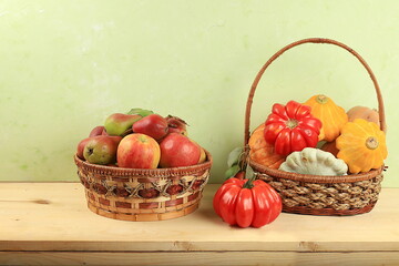 Basket with pumpkins, zucchini and apples on a wooden table. Autumn composition with gifts of nature, thanksgiving day concept, harvesting, banner or splash, postcard, rustic style,