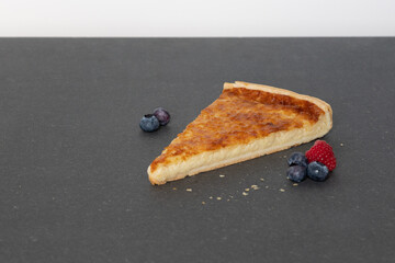 käsekuchen homemade auf schwarzem untergrund mit einigen beeren.