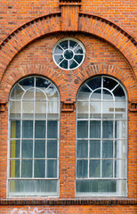 Fototapeta na wymiar Backsteingebäude mit Facettenfenster