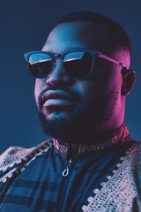 Obraz premium African fashion guy with sunglasses against dark background