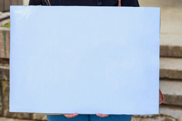 White sheet of whatman paper with place for text, blank or mockup. People with placards at protest...