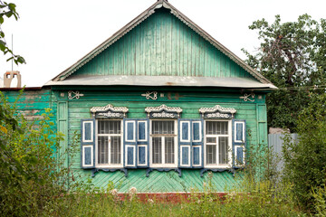 green old wooden house with carved windows in the Russian village