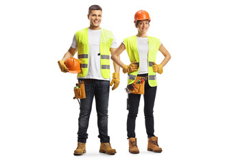 Full length portrait of a male and female construction workers wearing hardhats