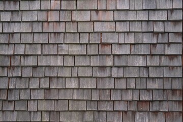 Shingle wooden tile facade background.Texture of old weathered wooden tiled roof or surface of...