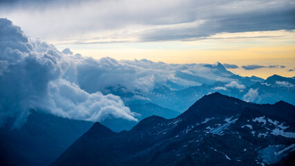 Rocky alpine mountains morning panorama. Cloudy sunrise on summer day. Grossglockner Mountain, Hohe Tauern National Park, Austrian Alps