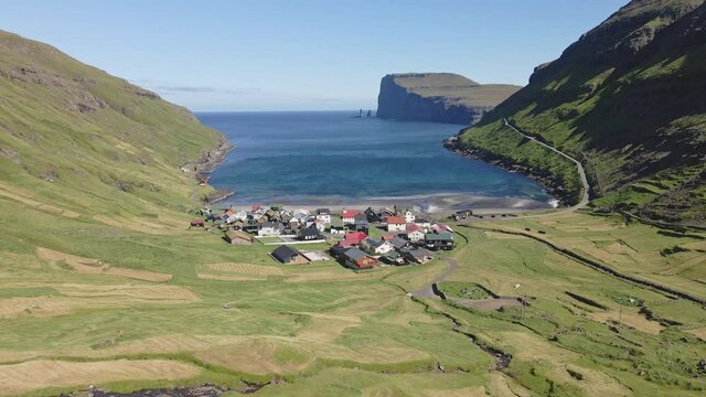 Drone Shot of Small Houses by the Ocean Waters in Tjornuvik,  Faroe Islands