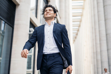 The financier is in a good mood and a modern business suit. The young businessman is confident. A male entrepreneur goes to work in the office.