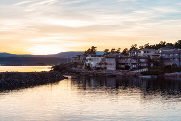 Fototapeta premium Scenic View of the residential homes on the West Pacific Ocean Coast. Summer Sunset. MacAulay Point Park in Victoria, Vancouver Island, British Columbia, Canada.